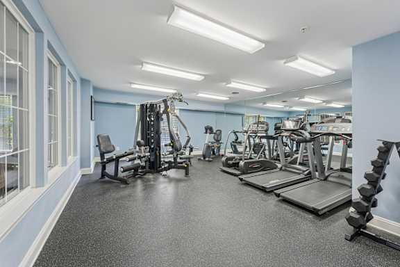 A spacious gym with a variety of equipment including treadmills, weights, and exercise machines.
